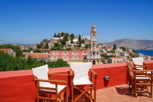 a table and chairs on a balcony with a view at Symi Uptown Carmine in Symi