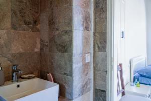 a bathroom with a tub and a sink at Symi Uptown Carmine in Symi