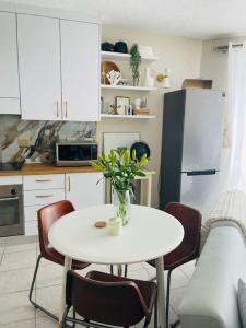 a kitchen with a table with a vase of flowers on it at A zen and chic beachfront apartment in Swakopmund
