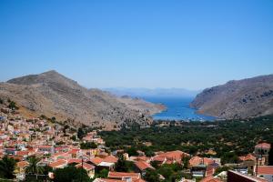 a view of a town on a hill with the ocean at Symi Uptown Carmine in Symi