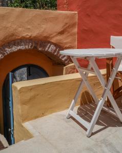 a white table and a chair in front of a building at Symi Uptown Carmine in Symi