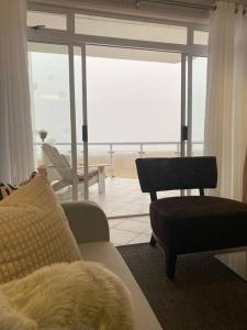 a living room with a couch and a chair at A zen and chic beachfront apartment in Swakopmund +27 photos