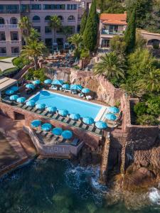an aerial view of a pool with chairs and a water slide at Tiara Miramar Beach Hotel & Spa in Th&eacute;oule-sur-Mer