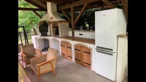 an outdoor kitchen with a stove and a refrigerator at Víz-Party vendégház in Dunasziget