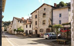 a car parked in front of a stone building at Chez Betty in Saint-Germain-de-Confolens