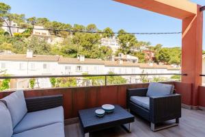 un patio avec deux chaises et une table sur un balcon dans l'établissement Piso reformado a pie de playa Sa Riera Begur, à Begur