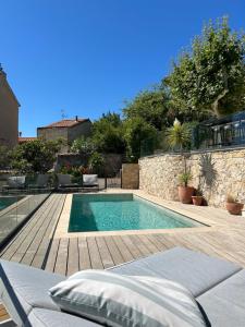 a swimming pool in a yard with a wooden deck at Maï Homes - La Villa Bompard in Marseille