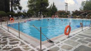 a large swimming pool with people in the water at "Rex Πολίτη" in Loutra Ipatis