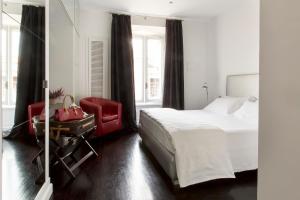 a bedroom with a bed, chair and a lamp at Xenia Guest House in Rome