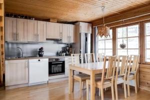 a kitchen with white cabinets and a table and chairs at Linnéan 2 in Lofsdalen