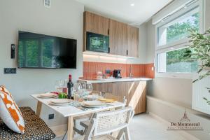 a kitchen with a table and chairs with wine glasses at De Montescal - SPA Tub and AC Cosy apartment a prime location 40m2 in Paris