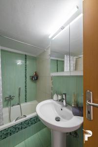 une salle de bain avec un lavabo et une baignoire dans l'établissement P Deluxe Suites A4, à Néa Michanióna