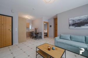un salon avec un canapé bleu et une table dans l'établissement P Deluxe Suites A4, à Néa Michanióna 19 autres photos