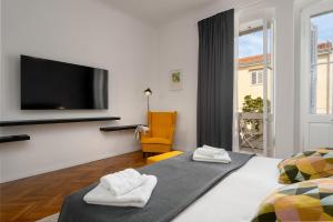 Un dormitorio con dos camas y un televisor de pantalla plana. en Romeo and Juliet Apartment with Balcony and Sea View, en Poreč