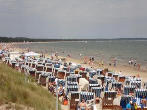 a beach with lots of chairs and people in the water at Ferienwohnungen im Haus Bi Henny in Baabe