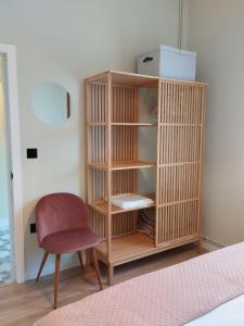 a wooden book shelf with a chair in a room at los Ojos de Bel in Trevías