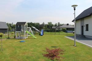 een park met een speeltuin met glijbaan bij Domki na Krótkiej in Spytkowice