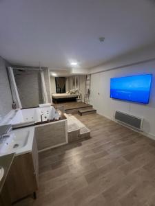 a bathroom with two sinks and a flat screen tv at Loft ravissant 45m2 Jacuzzi RVB NIGHT 2 ÉTABLISSEMENT FERMÉ DÉFINITIVEMENT in Amiens