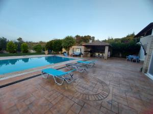 a pool with picnic tables and a gazebo at Luxury Arartments Tzemi in Porto Heli