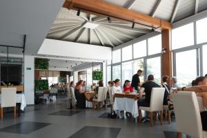 a group of people sitting at tables in a restaurant at Hotel Cajupi in Gjirokastër