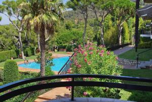 a view from a balcony of a swimming pool with flowers at Beach apartment overseeing the sea in Llafranc