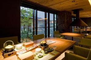 a dining room with a table and a large window at Kanemidori in Kusatsu