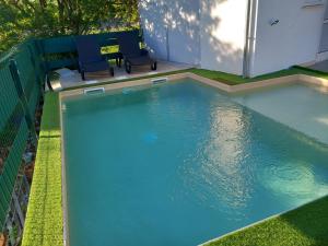 a swimming pool with two chairs in a yard at Apartments Ruzica in Pinezici