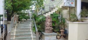a set of stairs with a statue in front of a building at Hotel City Palace in Brahmapur