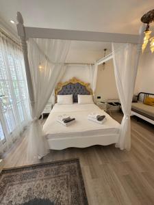 a bedroom with a white bed with a canopy at Grand Alaçatı Butik Hotel in Alaçatı