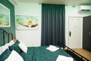 a bedroom with a green bed with two towels on it at Studio apartman Navis in Slavonski Brod