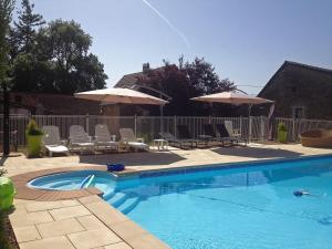 une piscine avec chaises et parasols dans l'établissement Gîtes L'Art d'une Pause, à Champagny-sous-Uxelles
