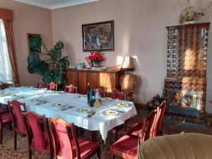 a dining room with a table and chairs and a fireplace at Pałac Stanica in Przeworno