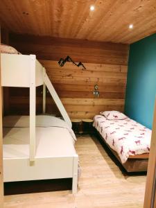a bedroom with a bunk bed in a wooden room at l'appartement montagnard d'Estelle 4-6 personnes in Lanslebourg-Mont-Cenis