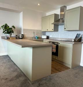 a kitchen with white cabinets and a counter top at Clock Tower Apartments 1 in Morecambe