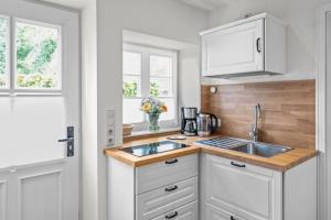 a kitchen with white cabinets and a sink at Lüdersburger Strasse 15b in Lüdersburg
