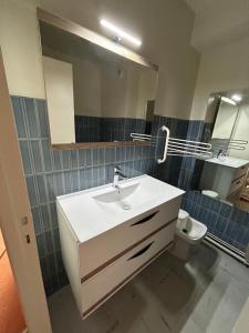 a bathroom with a sink and a mirror and a toilet at Vallonpierre2 in Orcières +3 photos