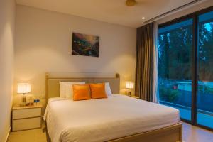 une chambre avec un lit avec des oreillers orange et une fenêtre dans l'établissement Villa Luxury 5 Phòng ngủ Hồ bơi riêng - Resort Sanctuary Hồ Tràm, à Xuyên Mộc 39 autres photos