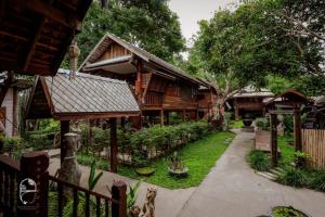 a courtyard of a house with trees and grass at Pastela Doi Saket Villa & Spa in Ban Pong