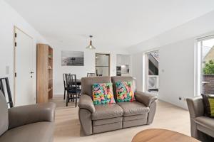 un salon avec une chaise et une table dans l'établissement Marlie s Home - comfort stadsapp met zonnig terras, à Nieuport