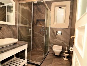 a bathroom with a shower and a toilet at Grand Alaçatı Butik Hotel in Alaçatı