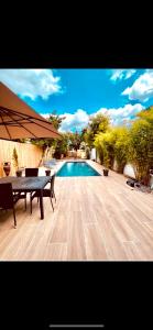 eine Terrasse mit Tisch und Swimmingpool in der Unterkunft Villa du Bouscat in Le Bouscat