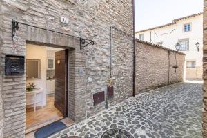 un mur en pierre avec une porte dans un bâtiment dans l'établissement IL RIFUGIO casa vacanze centro storico confortevole posto auto, à Nocera Umbra