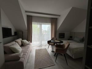 a living room with a couch and a bed at LaMira Apartment in Hajdúszoboszló
