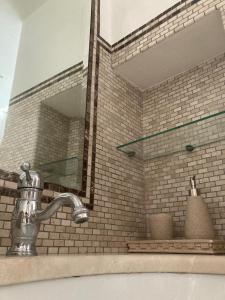 ein Waschbecken mit einem Spiegel an einer Backsteinwand in der Unterkunft Casa Angolo dei Sogni in Martina Franca