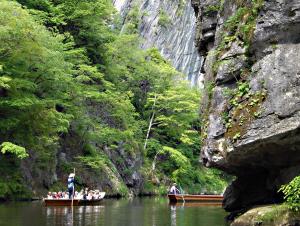 a group of people in a boat on a river at koyado kaziya in Ichinoseki