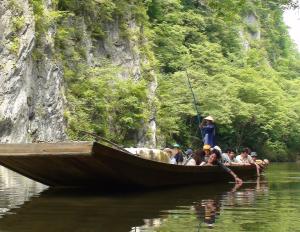 a group of people on a boat in the water at koyado kaziya in Ichinoseki
