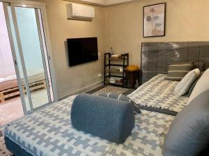 a bedroom with a large bed and a television at Au Riad Des Sultans - Marrakech in Marrakech