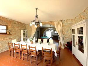 コルトーナにあるVilla Fattoria Le Giareのテーブルと椅子、ビリヤード台のあるダイニングルーム