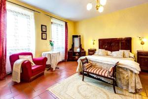 コルトーナにあるVilla Fattoria Le Giareの大きなベッドと椅子のある寝室 +49枚の写真
