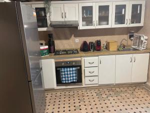 a kitchen with white cabinets and a refrigerator at Au Riad Des Sultans - Marrakech in Marrakech